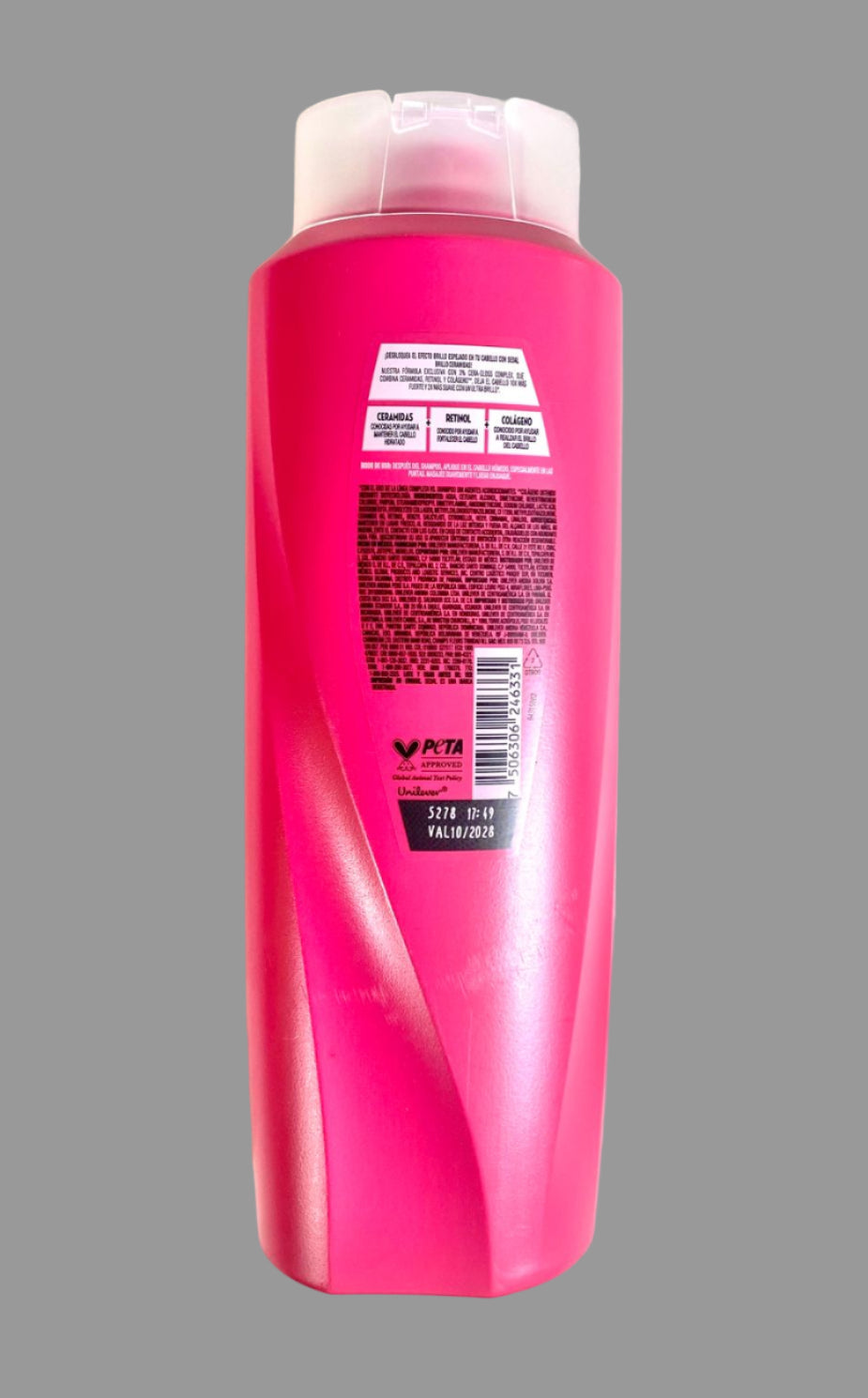 Pink shampoo bottle with a white cap on a light gray background