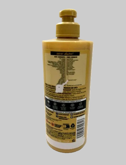 A bottle of hair developer (oxidizer) shown from the back, featuring a yellow body and a gold cap, with the back label facing the camera on a solid gray background.