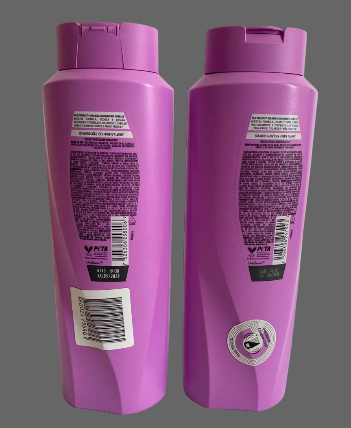 Two purple plastic shampoo bottles shown from the back, standing upright against a plain off-white wall and surface.